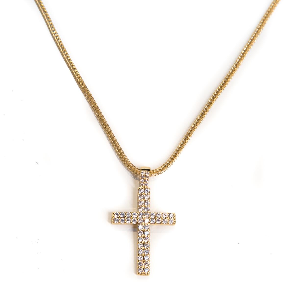 close up of the gold cross necklace chain on a white background