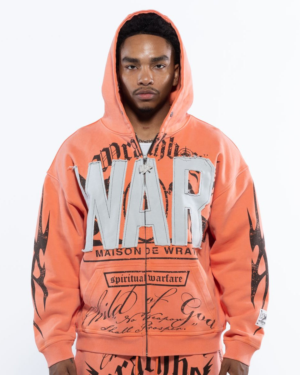 Person wearing an orange hoodie with text and graphics on a white background
