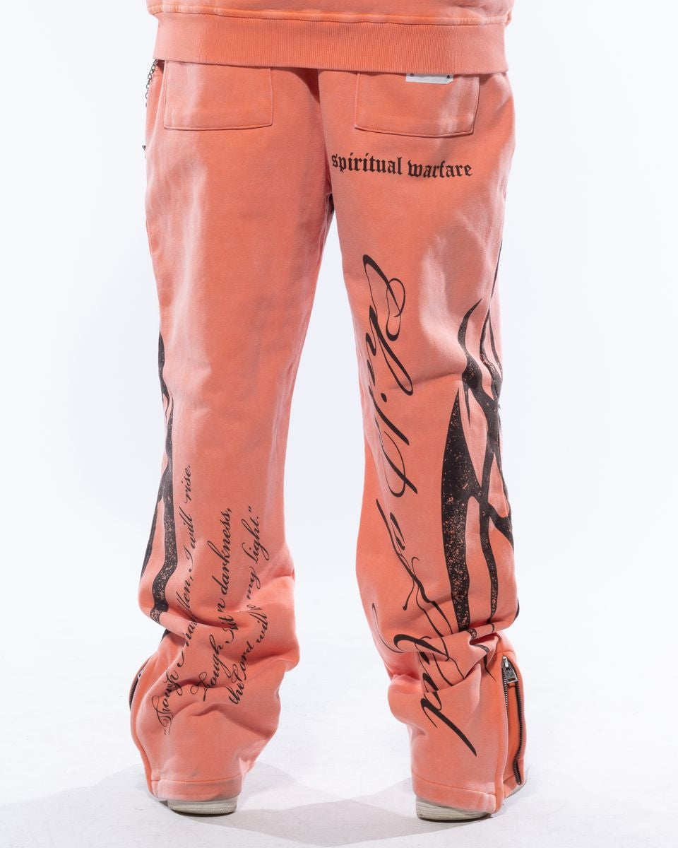 Peach-colored pants with black text and designs on a white background