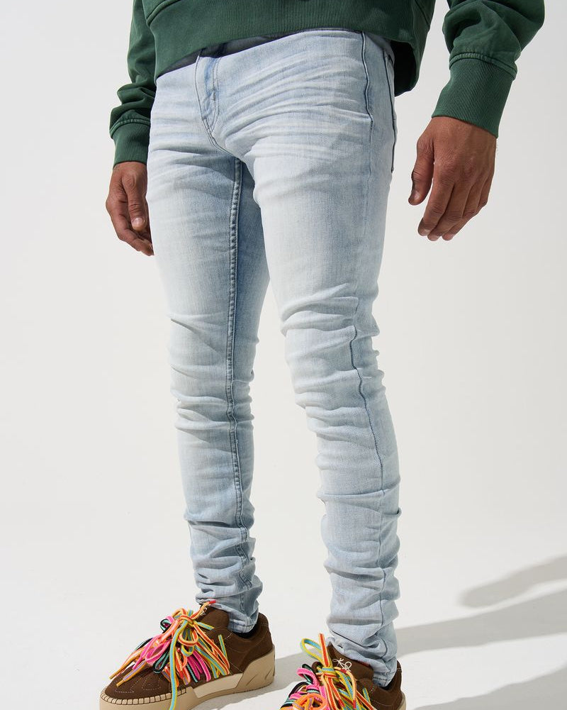 Person wearing light blue jeans and colorful sneakers on a white background
