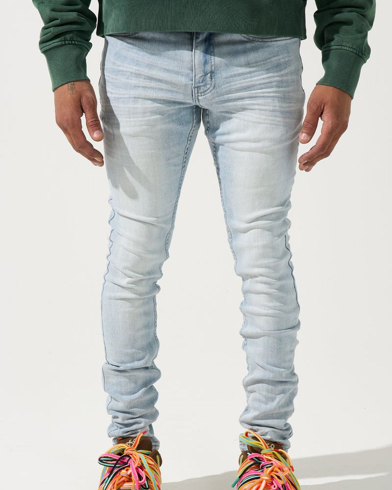 Person wearing light blue jeans and colorful sneakers on a white background