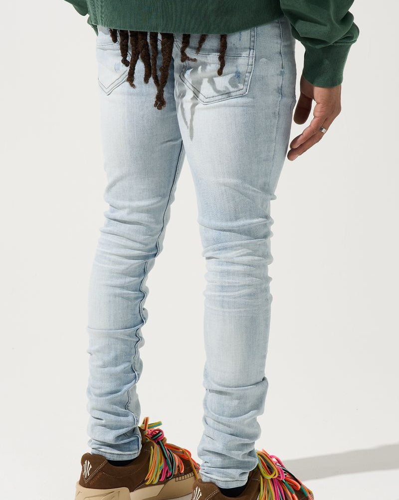 Person wearing light blue jeans and colorful sneakers on a white background