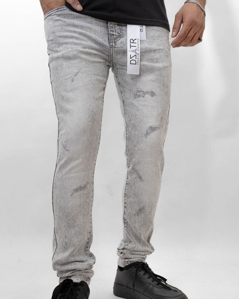 Person wearing gray distressed jeans with a visible brand label on a white background