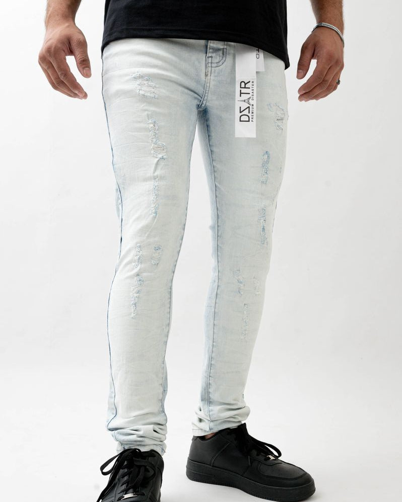 Person wearing light blue distressed jeans with a visible brand label on a white background