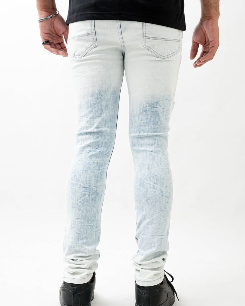 Person wearing light blue distressed jeans on a white background