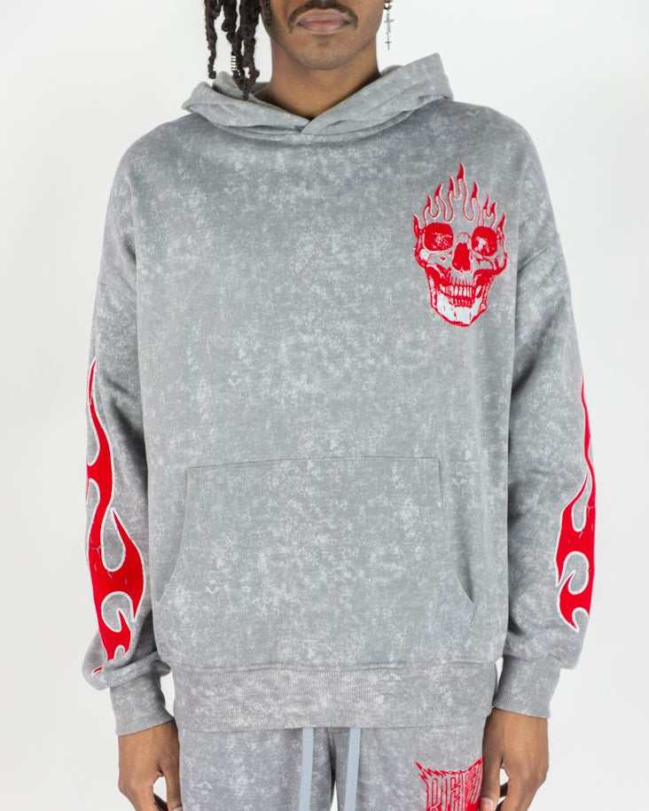 Gray hoodie with red skull designs on sleeves and pants worn by a person against a white background