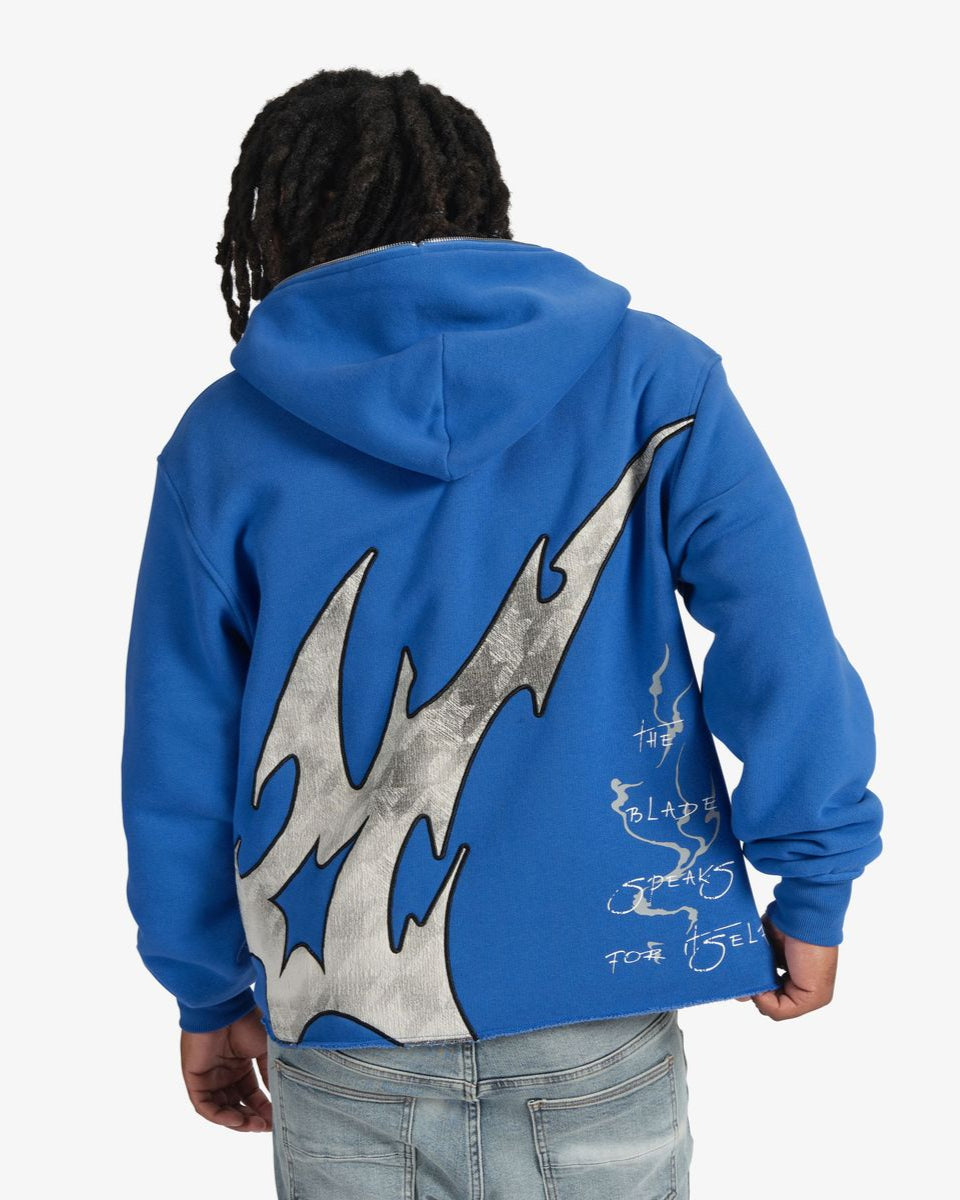 Person wearing a blue hoodie with a large gray and blue design on the back, on a white background