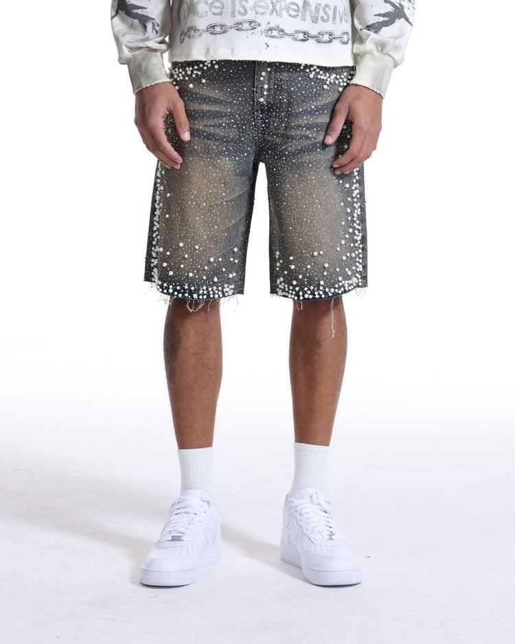 Person wearing a white sweatshirt with text, denim shorts with star patterns, and white sneakers on a white background
