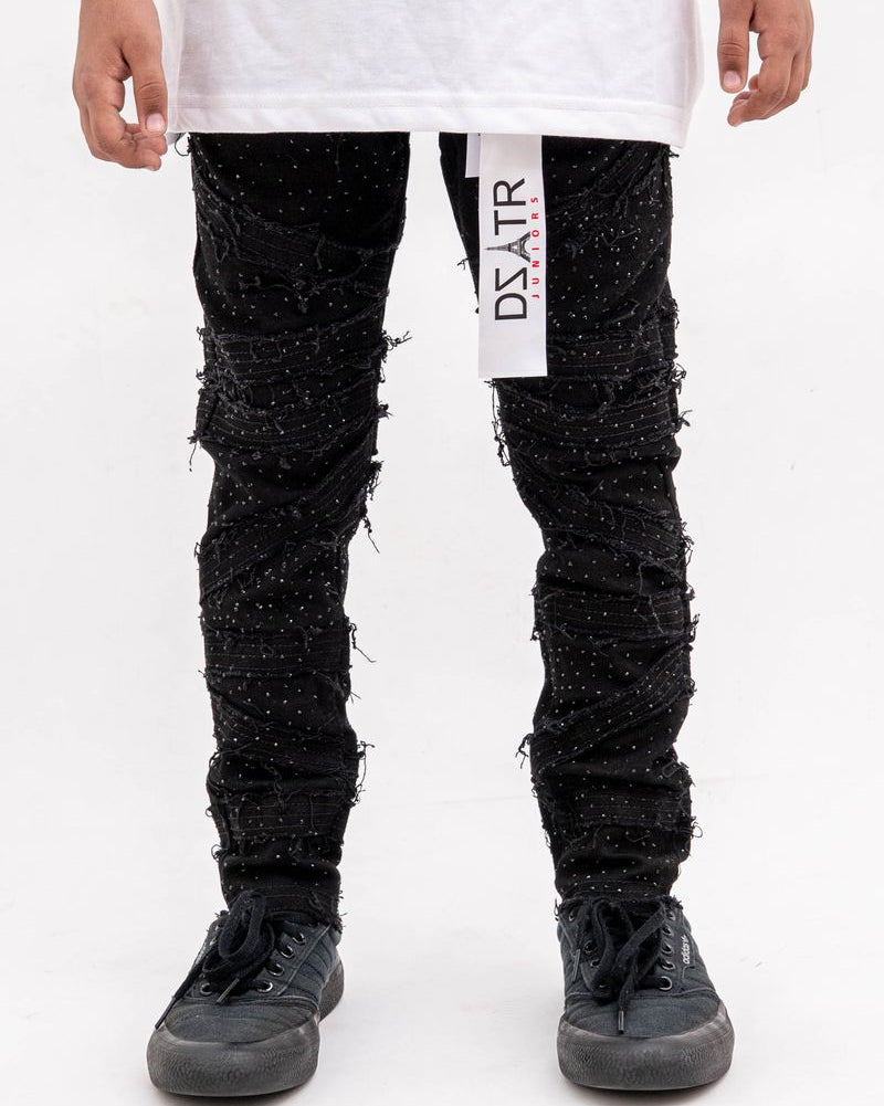 Person wearing black textured pants with a white label on a white background