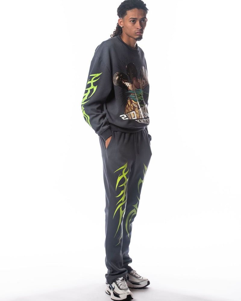 Person wearing a gray tracksuit with green designs on a white background