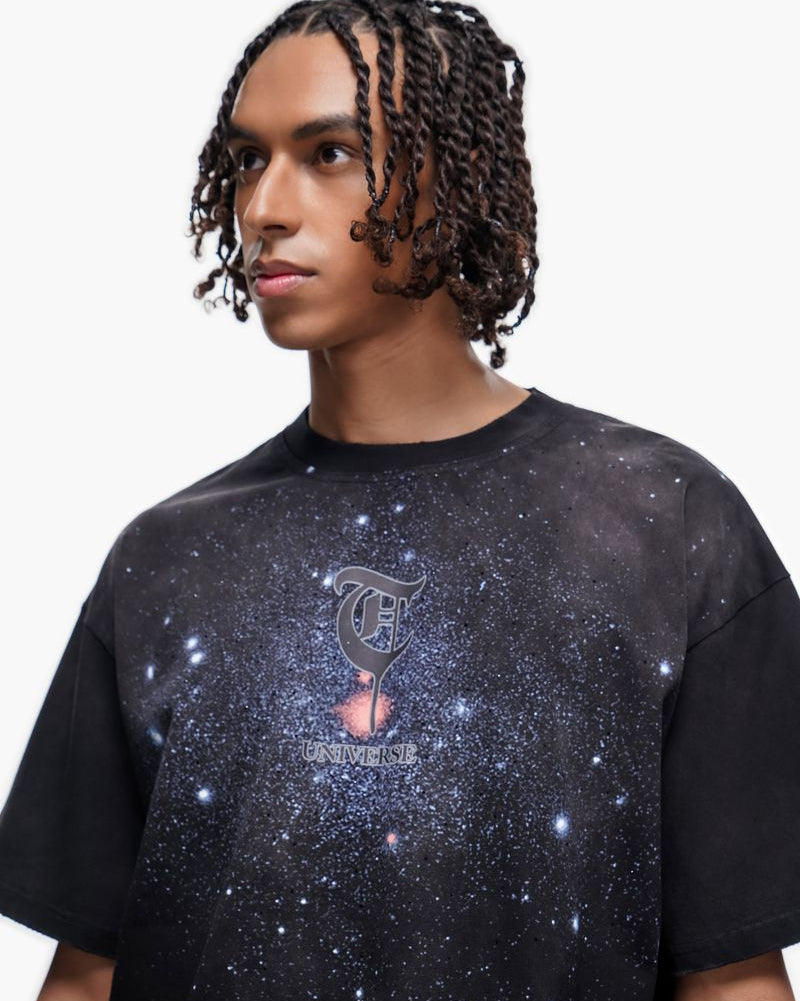 Person wearing a black t-shirt with a galaxy design and logo on a white background