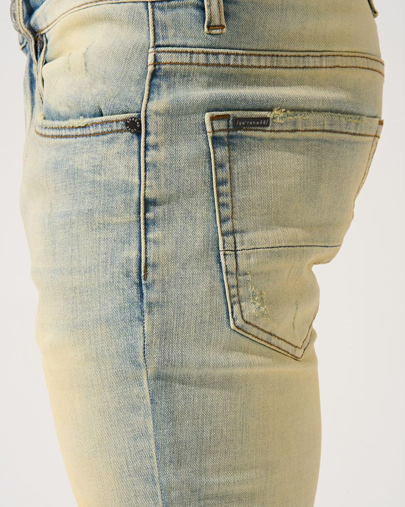 Light blue denim jeans with a brand logo on a white background