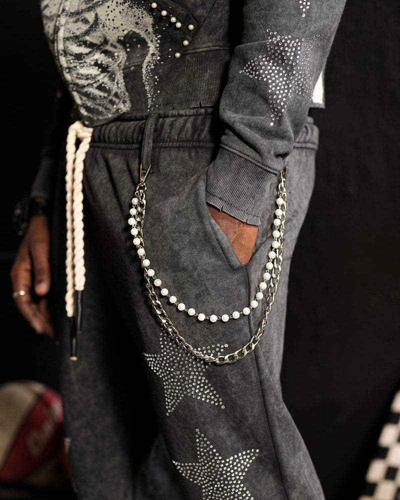 Gray pants with star patterns and rhinestones, worn by a person.