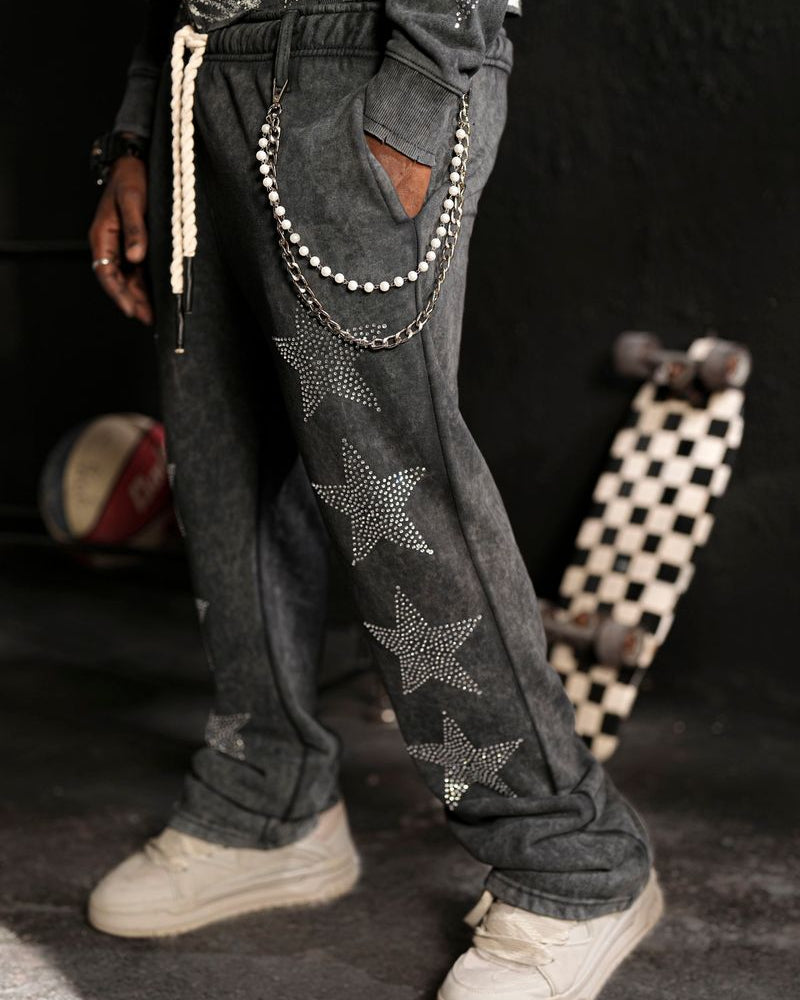 Person wearing dark jeans with star patterns and a longboard in the background