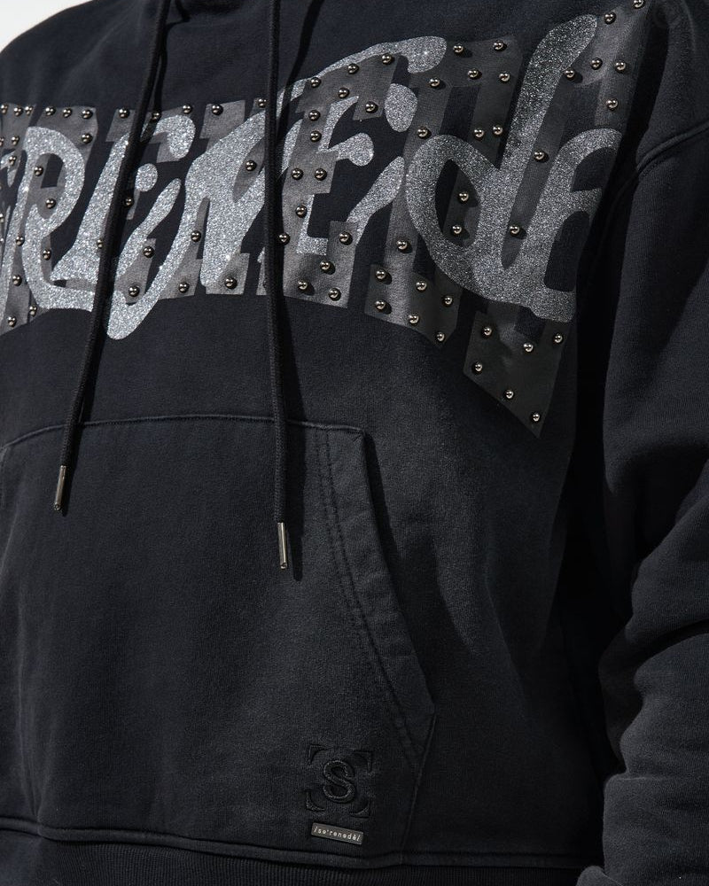 Black hoodie with studded text design on a dark background