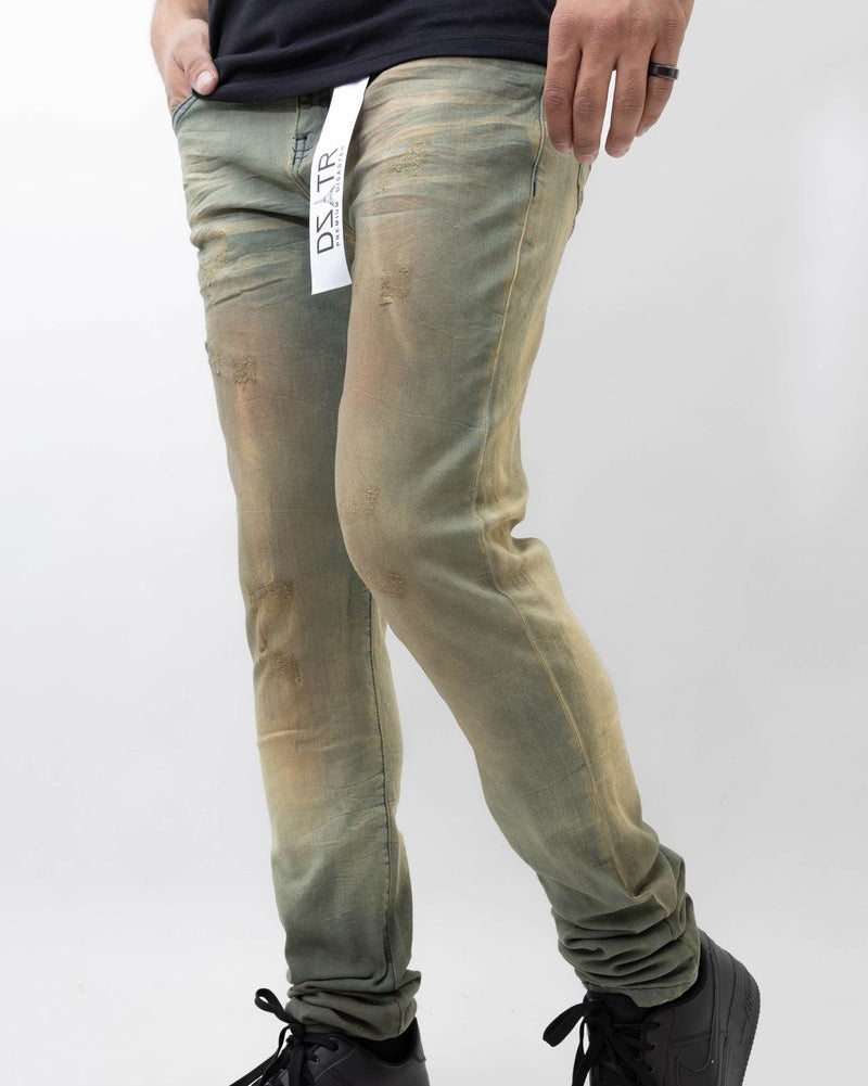 Person wearing light green jeans and black shoes on a white background
