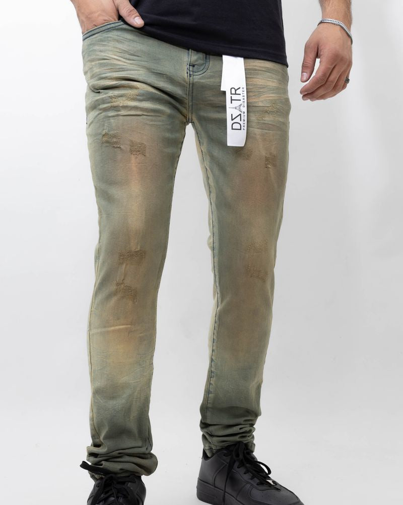 Person wearing green distressed jeans with a visible brand label on a white background