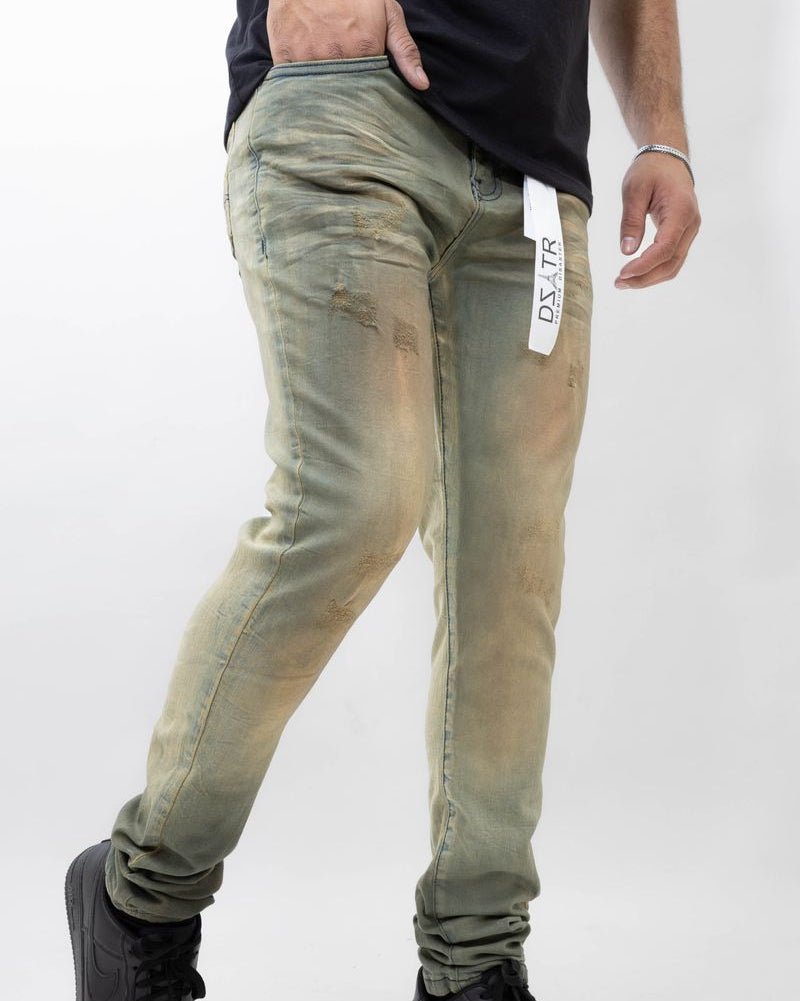 Person wearing green distressed jeans with a visible brand tag on a white background