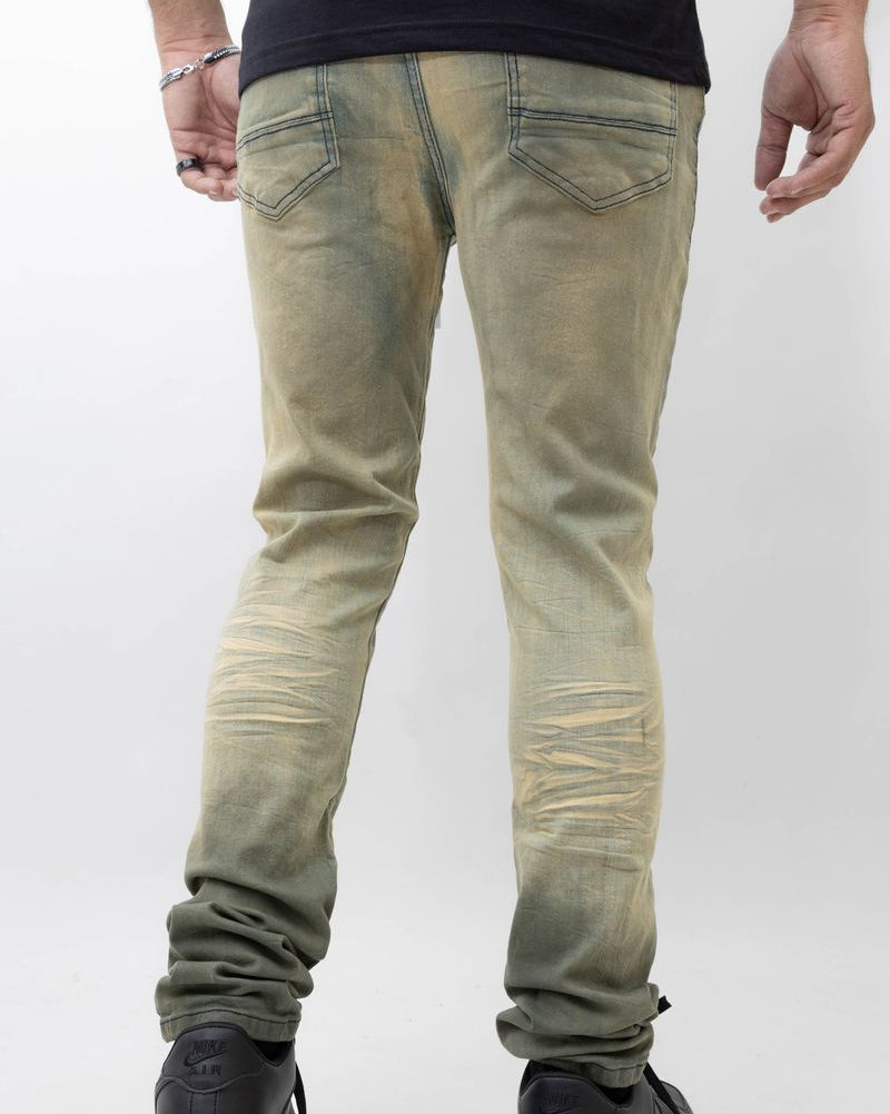 Person wearing light green distressed jeans on a white background