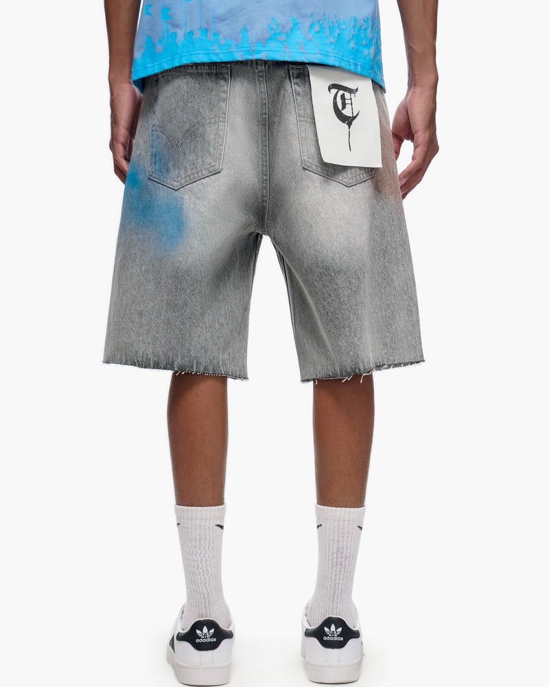 Person wearing gray denim shorts with a white logo on a white background