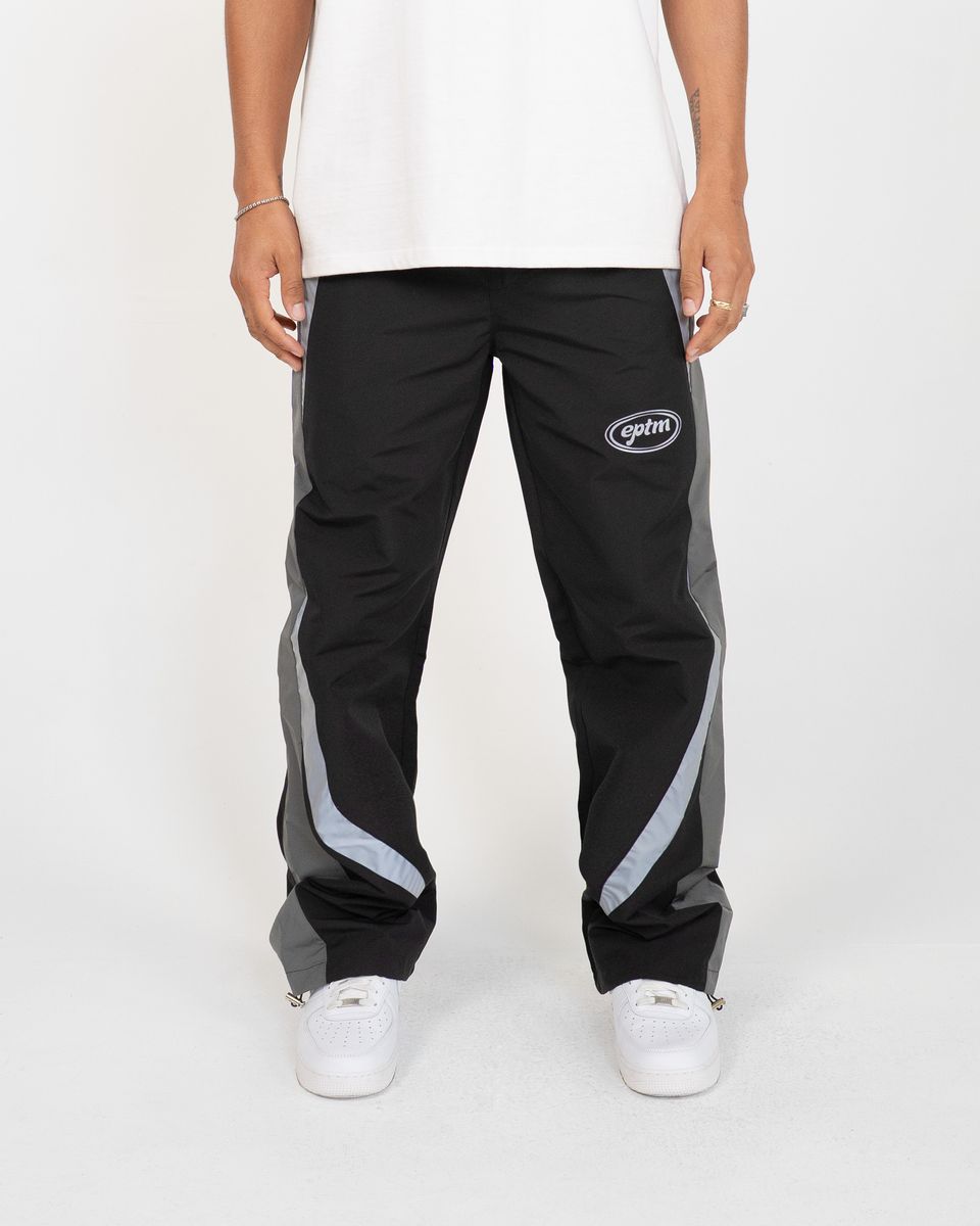 Person wearing black pants with gray stripes and a logo on a white background