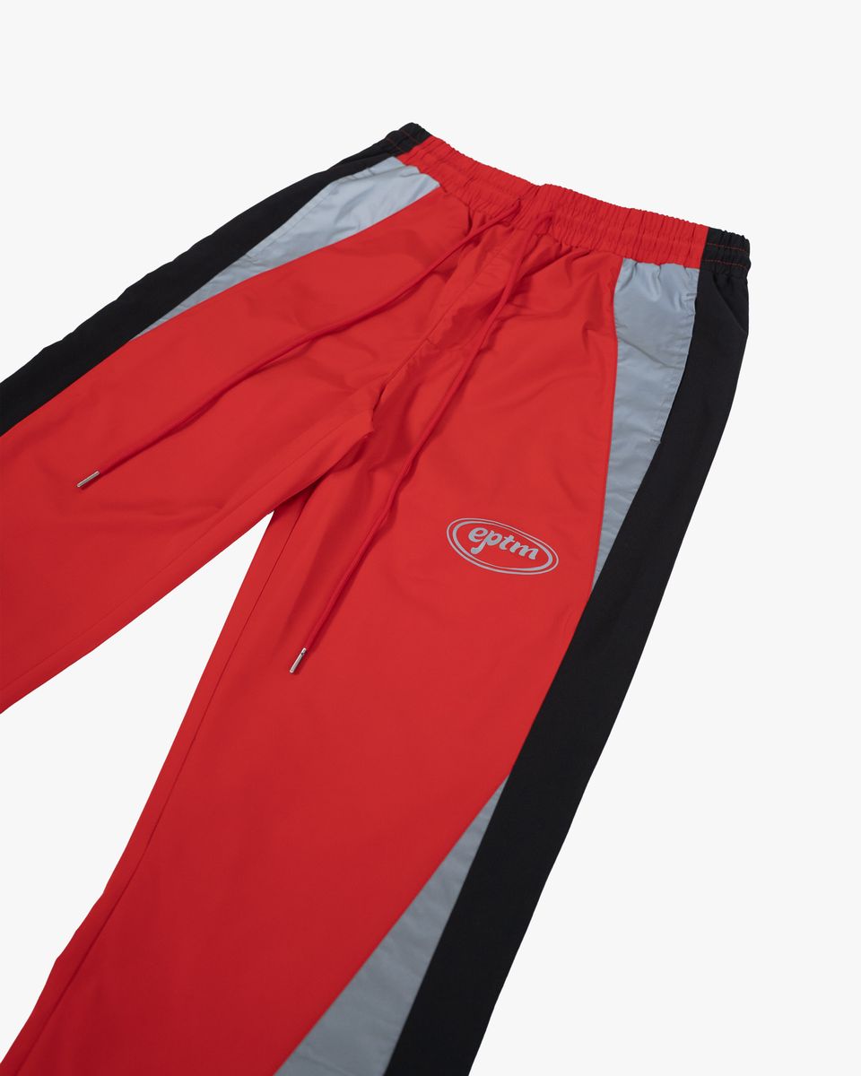 Red and black tracksuit pants with a logo on a white background