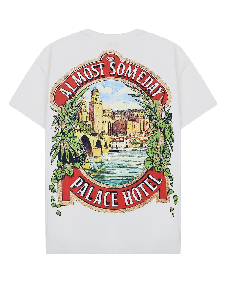 cream t-shirt with 'Almost Someday Palace Hotel' graphic design on a white background