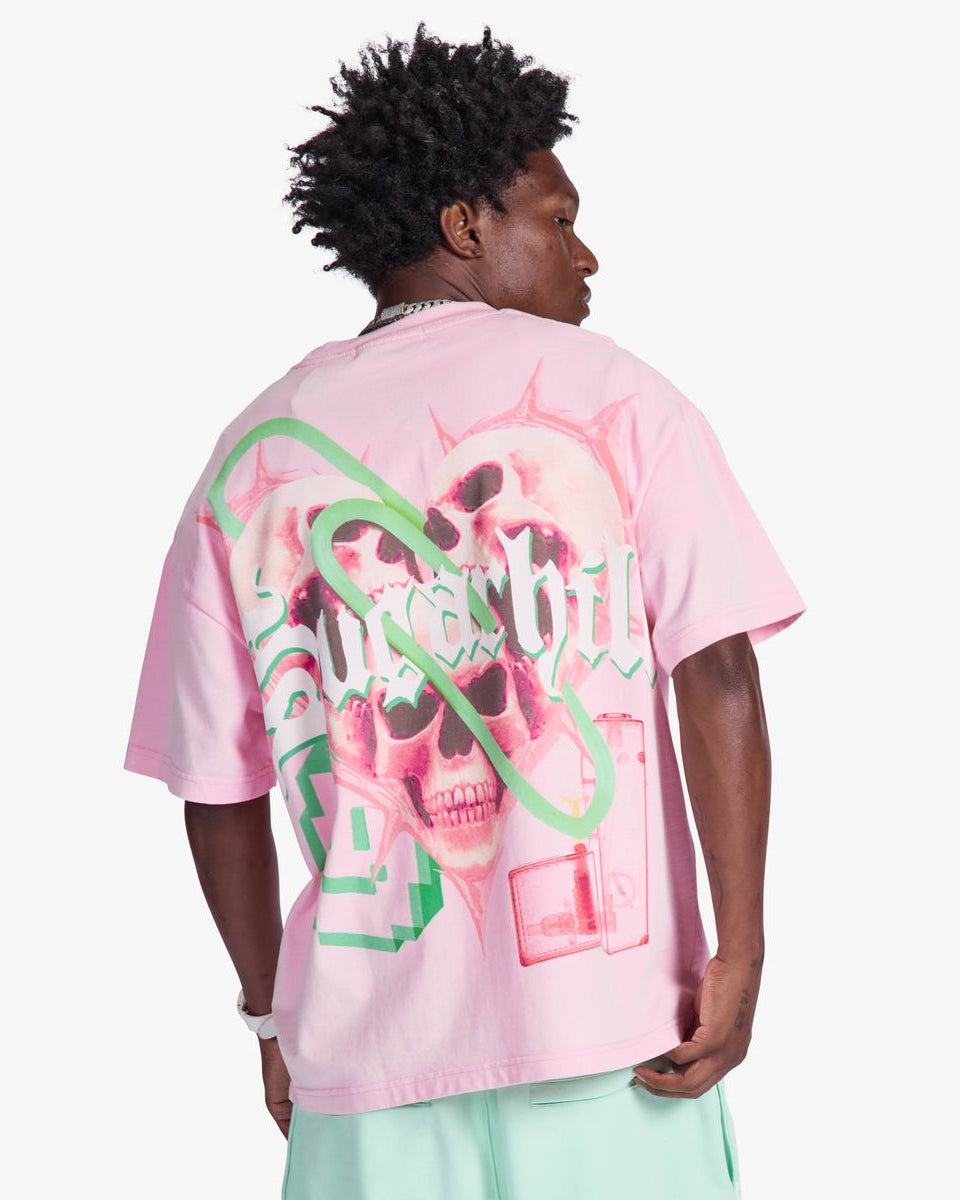 Person wearing a pink t-shirt with a graphic design on the back, standing against a white background