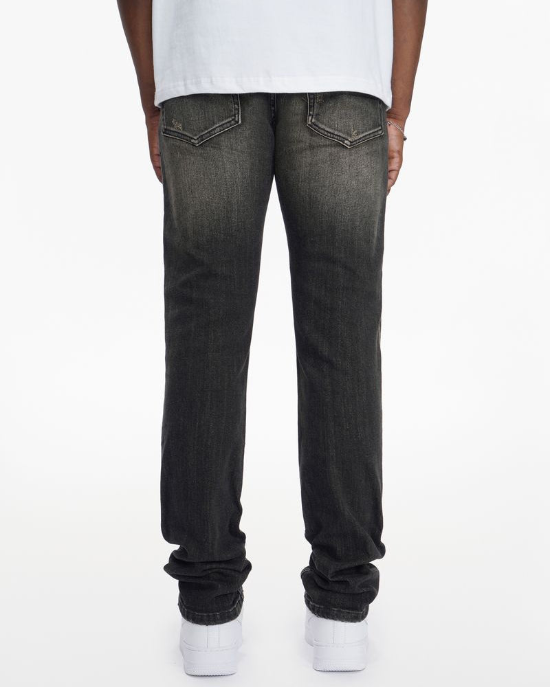 Person wearing black jeans and white sneakers on a white background