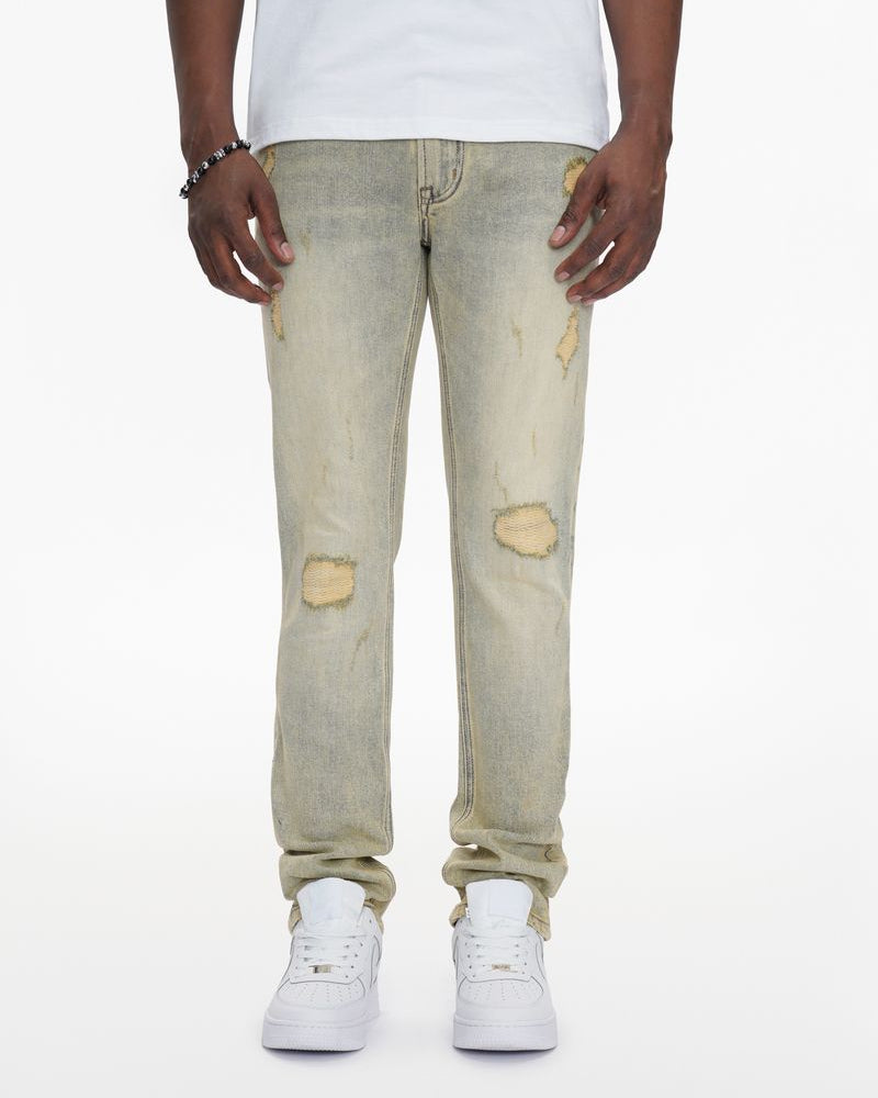 Person wearing light-colored distressed jeans and white sneakers on a white background