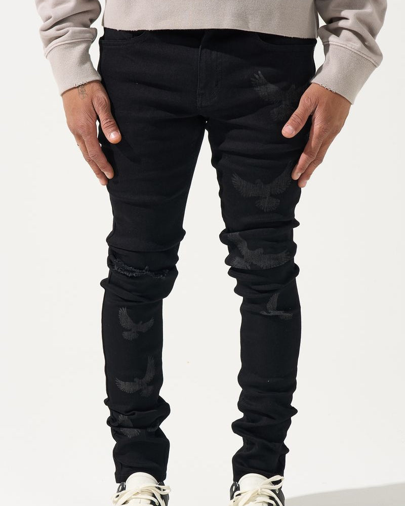 Person wearing black jeans and white sneakers on a white background