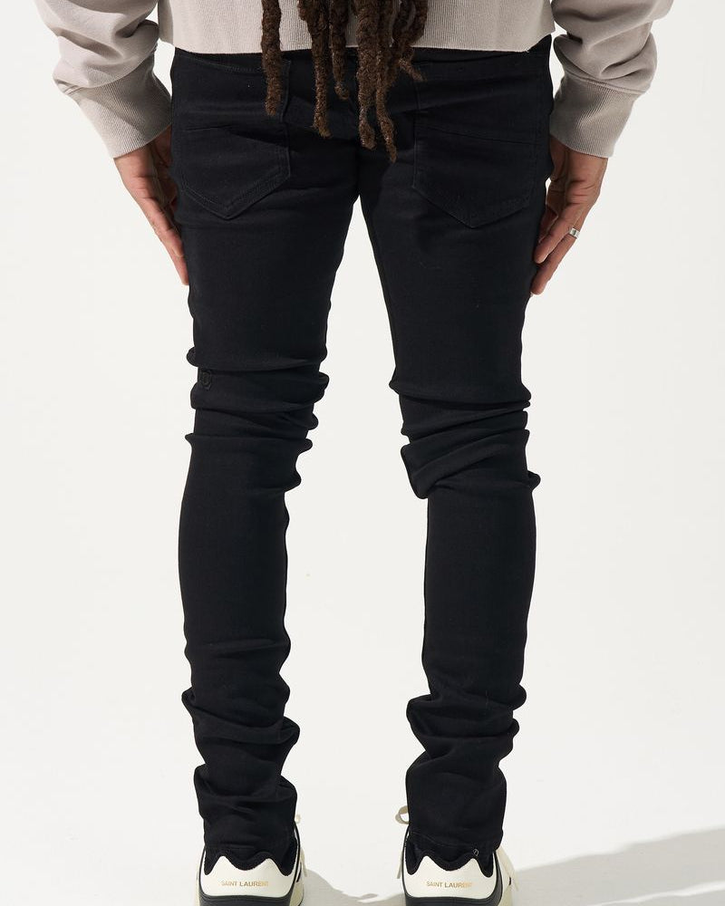 Person wearing black jeans and a light-colored top on a white background