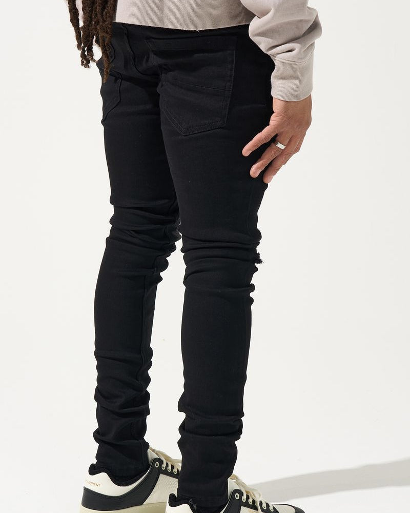 Person wearing black pants and white sneakers on a white background