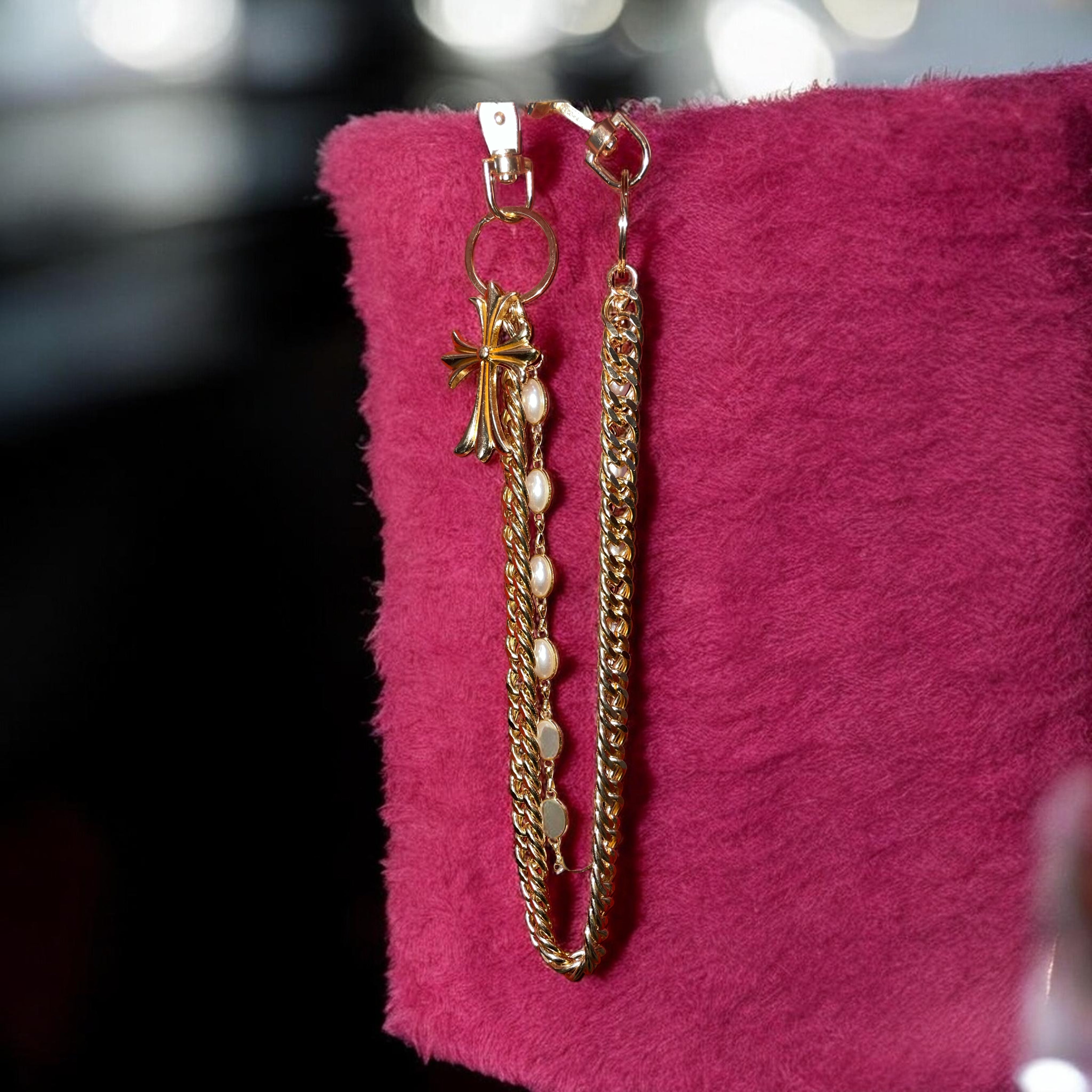 Gold chain on a pink surface with blurred background
