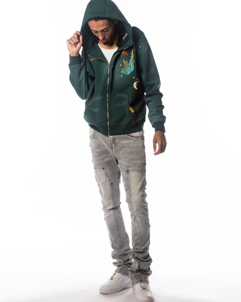 Person wearing a green hoodie and gray pants on a white background