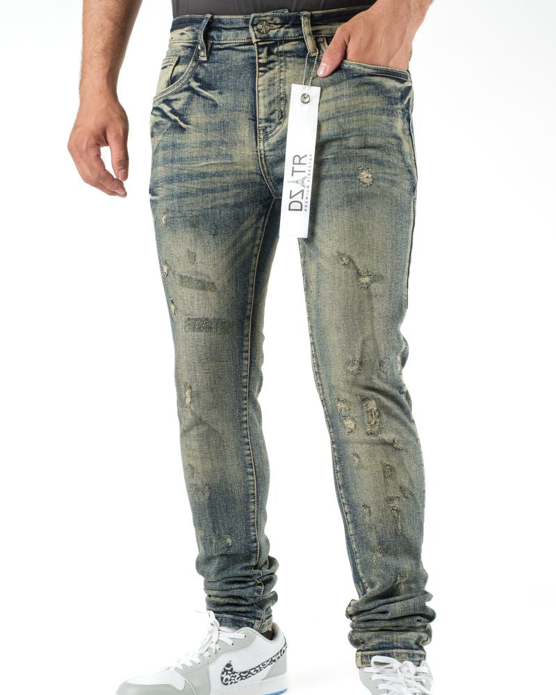 Person wearing distressed blue jeans with a visible brand tag on a white background