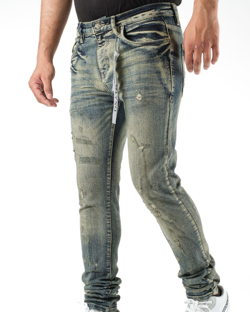 Distressed blue jeans worn by a person on a white background