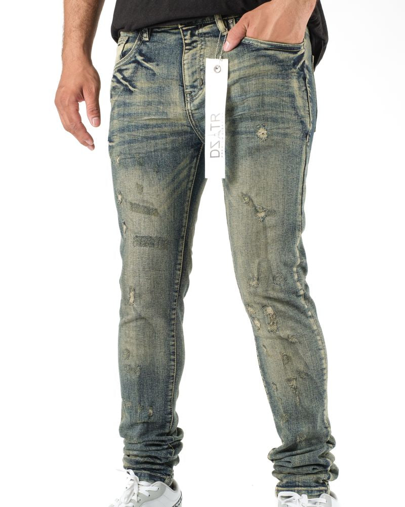 Distressed blue jeans worn by a person on a white background