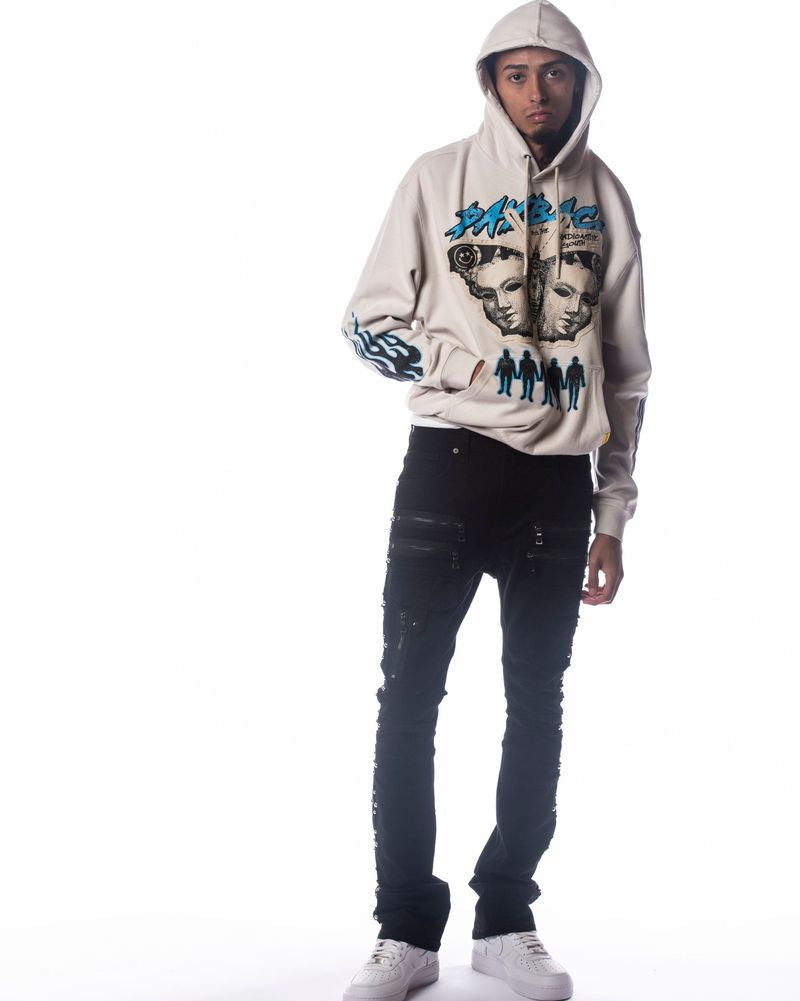 Person wearing a graphic hoodie and black jeans on a white background