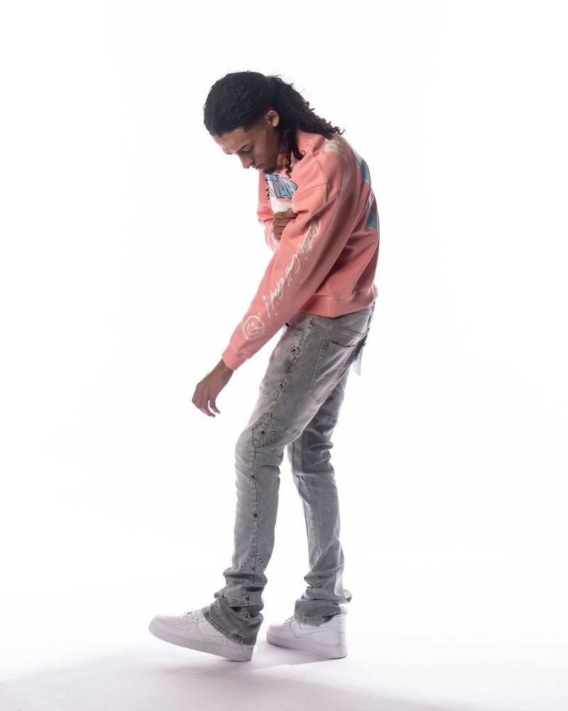 Person wearing a pink sweatshirt and gray pants on a white background