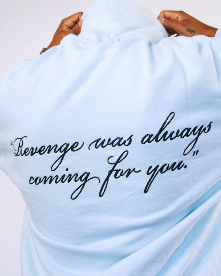 Light blue sweatshirt with text 'Revenge was always coming for you' on a white background