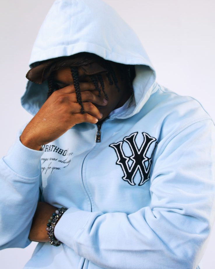 Person wearing a light blue hoodie with a logo on a white background