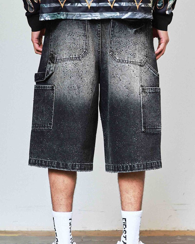 Person wearing black gradient shorts with a plain background
