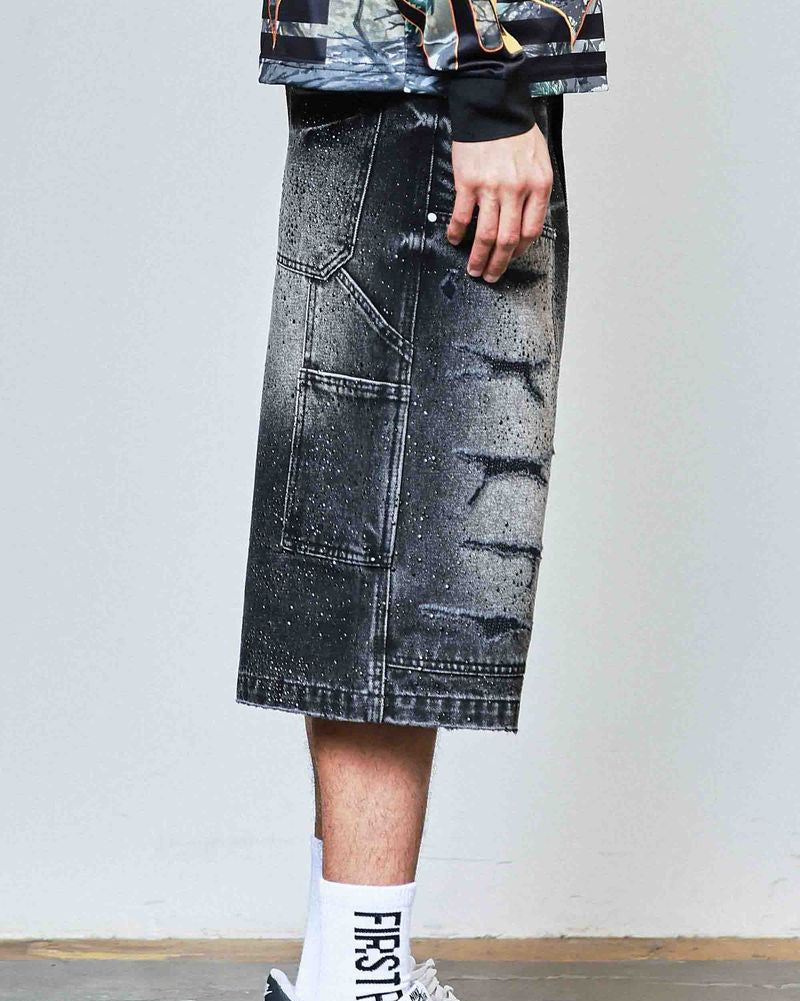 Person wearing a black denim skirt with a plain background