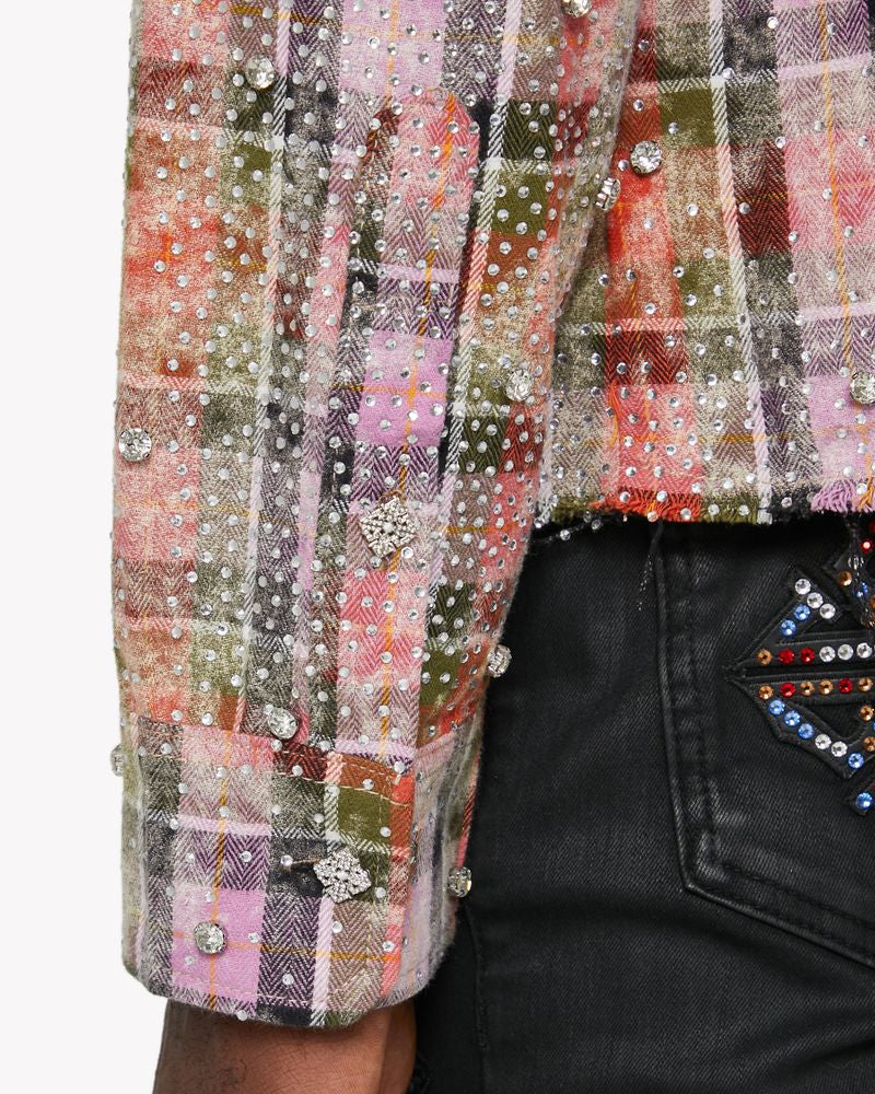 Close-up of a colorful plaid shirt with sequins and a black jacket with a decorative pocket.