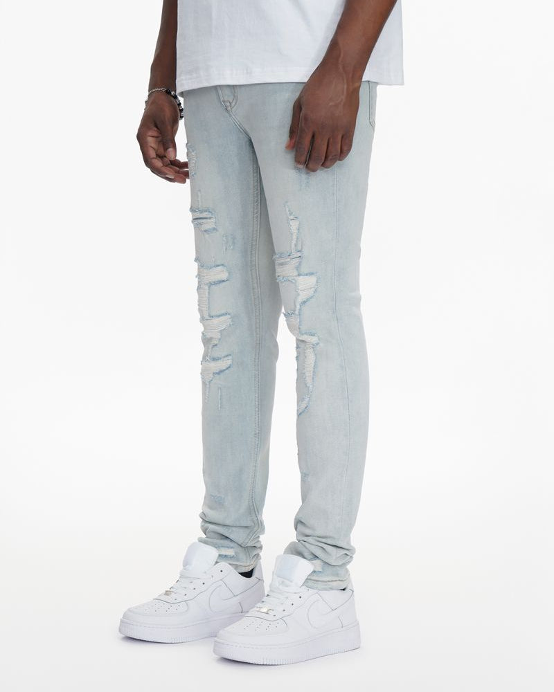 Light blue distressed jeans worn by a person on a white background
