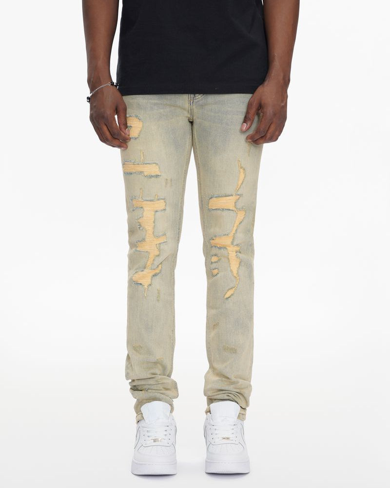 Person wearing light-colored distressed jeans and white sneakers on a white background