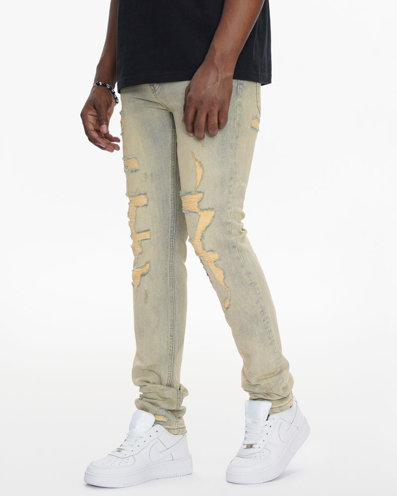 Person wearing light-colored distressed jeans and white sneakers on a white background