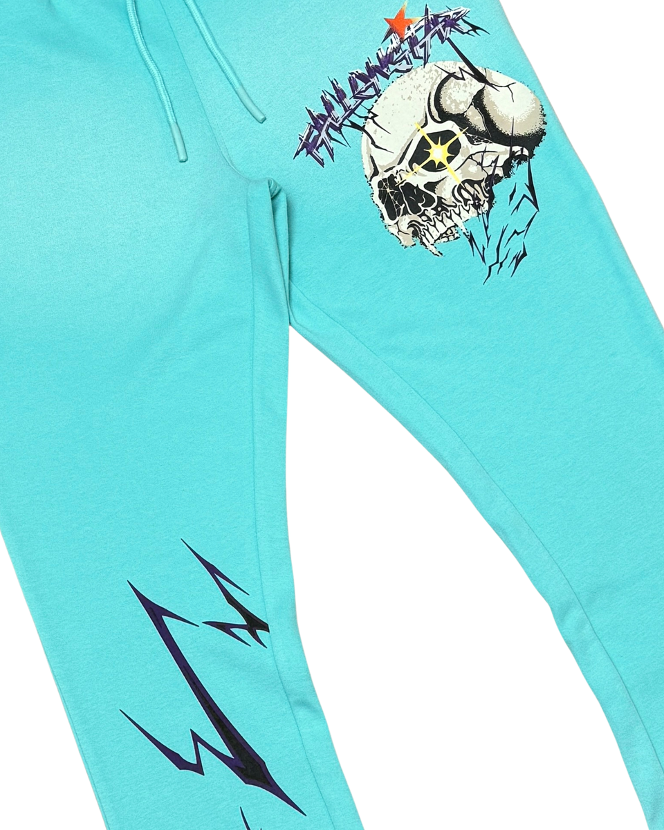Turquoise sweatpants with a skull design and text on a white background