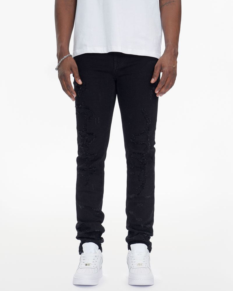 Person wearing black jeans and white sneakers on a white background